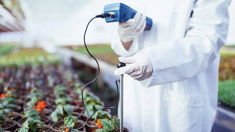 Woman testing ph level in a greenhouse